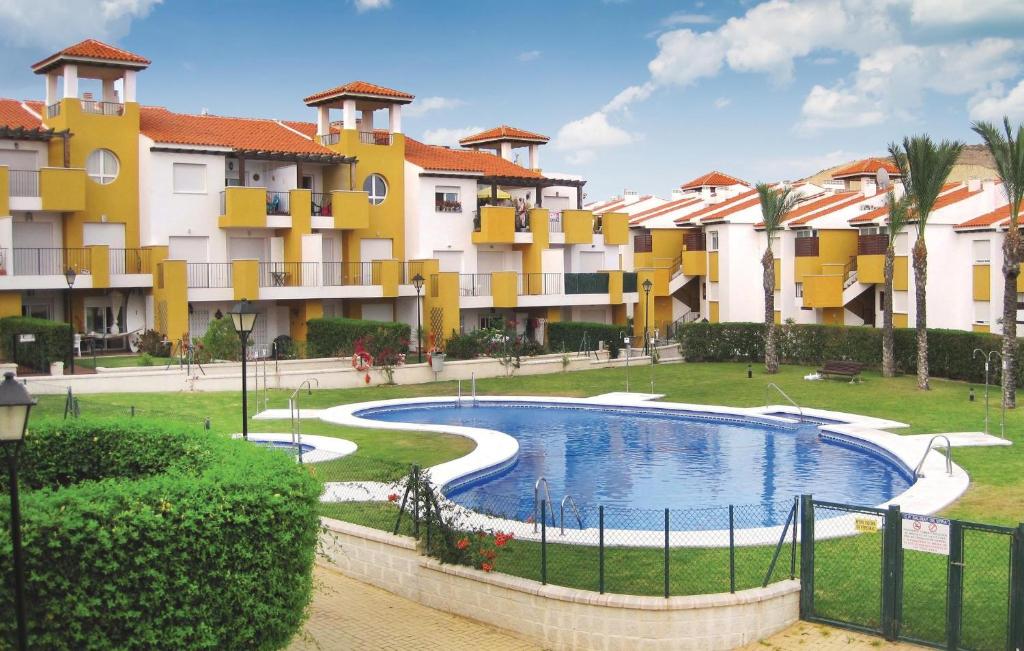 Media LeguaにあるBeautiful Apartment In Vera Playa With 2 Bedrooms, Wifi And Indoor Swimming Poolの一部の建物の前にスイミングプールがあります。