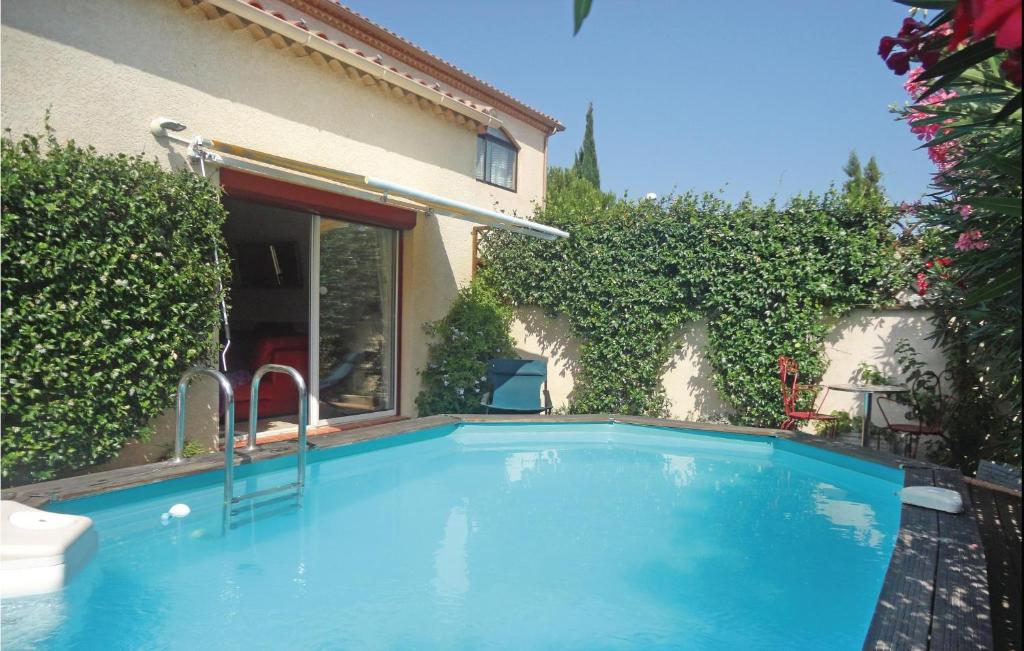 - une piscine en face d'une maison dans l'établissement Nice Home In Villeneuve Les Beziers With 2 Bedrooms, Wifi And Private Swimming Pool, à Cers