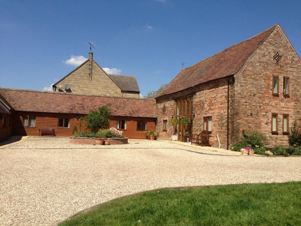 an old brick building with a cross on top of it at Bridge Farm Holiday Cottages in Cow Honeybourne