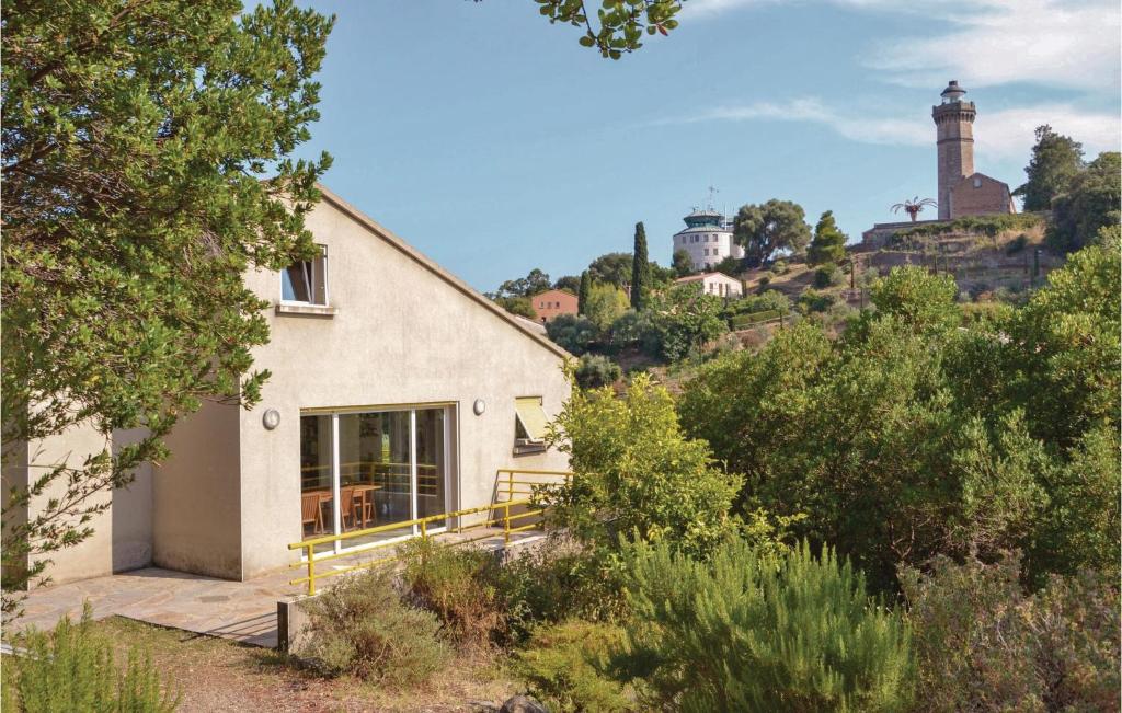 une maison blanche sur une colline avec un phare en arrière-plan dans l'établissement Cozy Home In San Giuliano With Wifi, à San-Giuliano