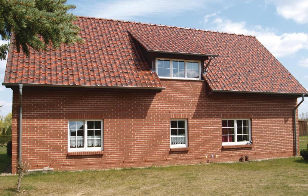 a red brick house with three windows and a roof at 2 Bedroom Pet Friendly Apartment In Mirow Ot Qualzow in Qualzow