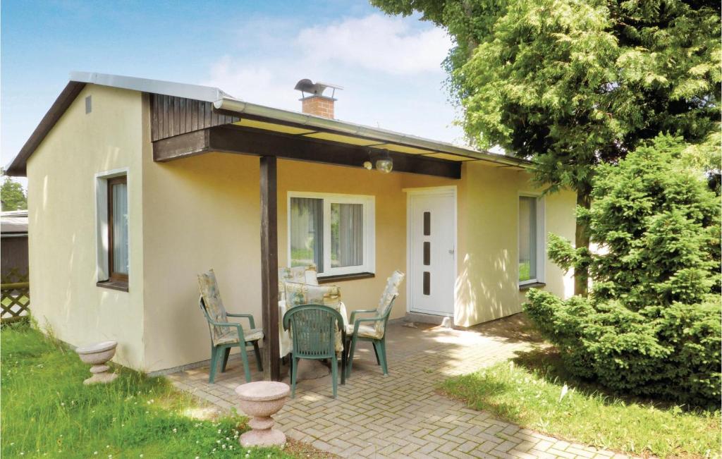 ein kleines gelbes Haus mit einem Tisch und Stühlen in der Unterkunft Ferienhaus Hauptstrasse B in Eichigt