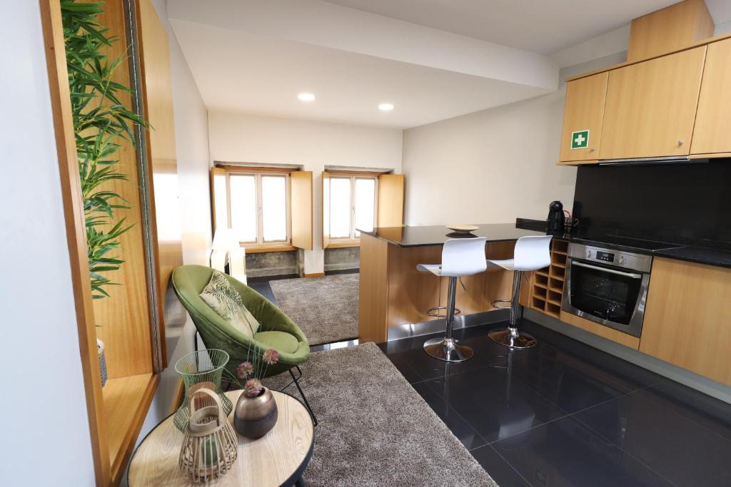 a living room with a kitchen with a table and chairs at Anjinho City Center in Viana do Castelo