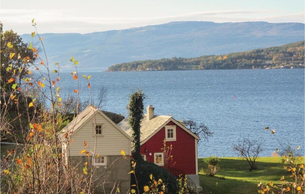 a red house next to a large body of water at Beautiful Home In Jondal With Kitchen in Jondal