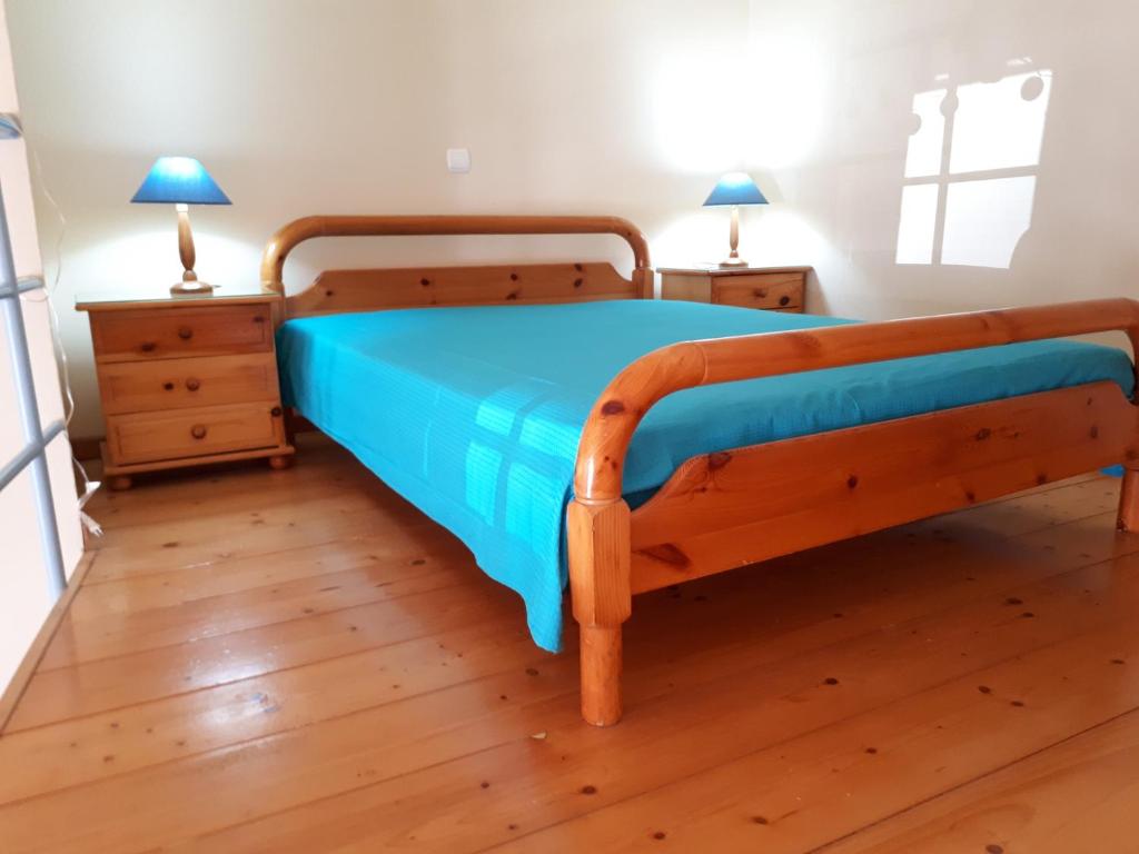 エルムポリにあるErmoupolis, Syros City Apartmentsのベッドルーム1室(木製ベッド1台、ナイトスタンド2台付)