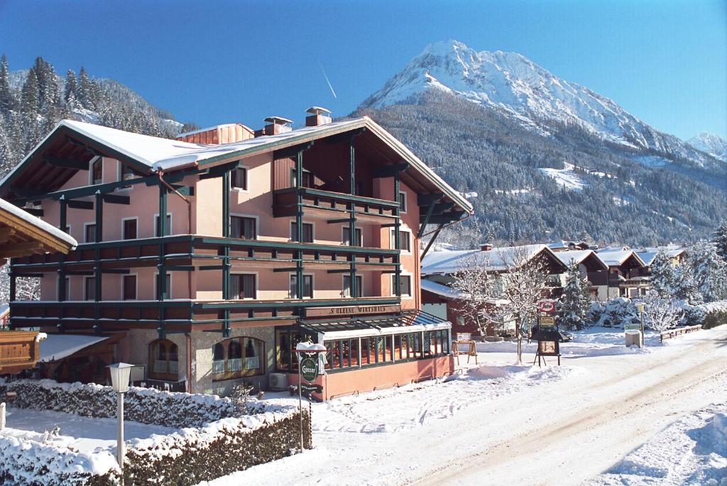 un grande edificio nella neve con una montagna di Hotel Alpina a Kleinarl