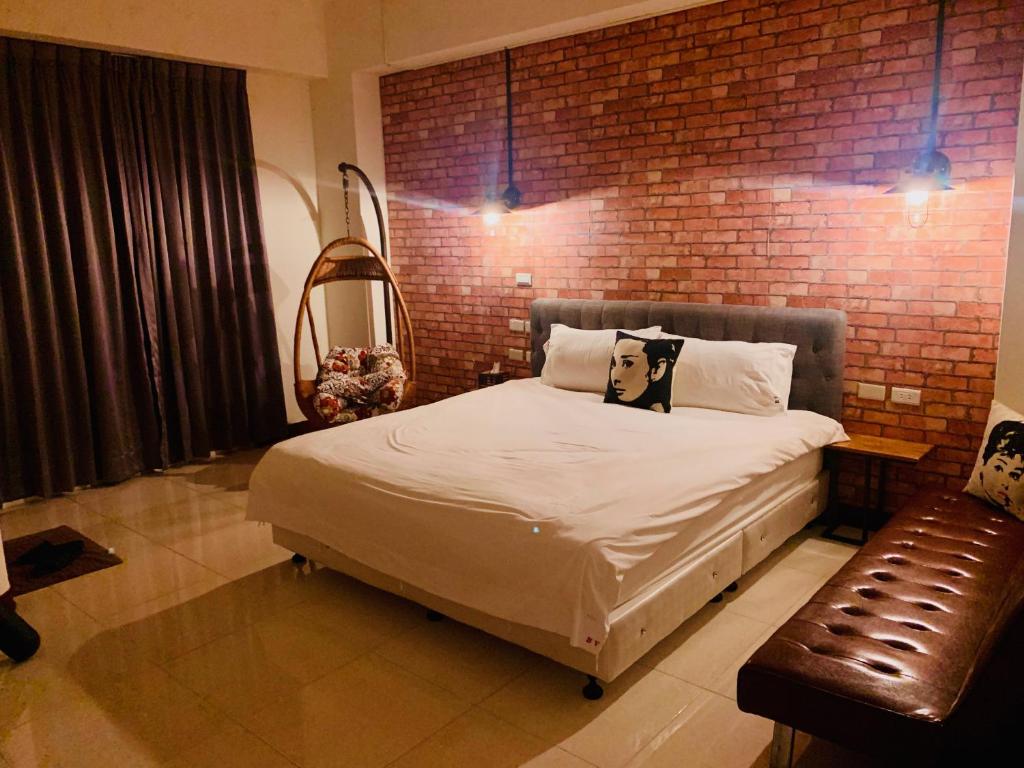 a bedroom with a bed and a brick wall at Hualien BV B&B in Hualien City