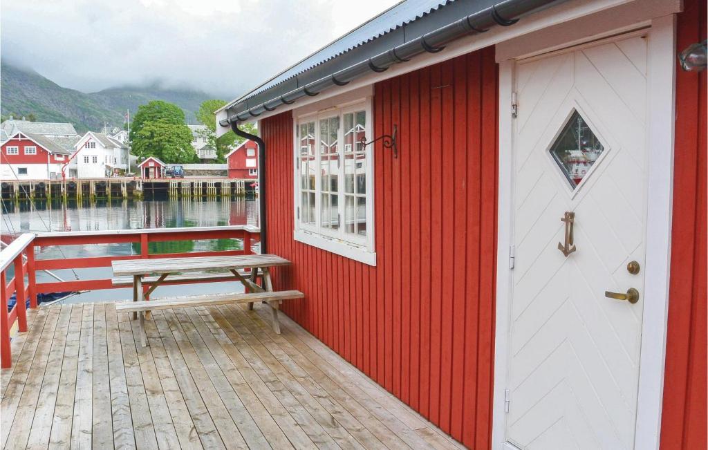 a red building with a picnic table on a dock at Amazing Home In Srvgen With Wifi in Sørvågen