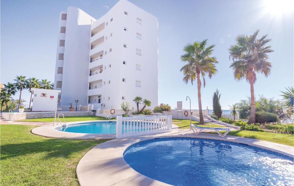 a swimming pool in front of a building at Nice Apartment In Calahonda With Outdoor Swimming Pool in Sitio de Calahonda