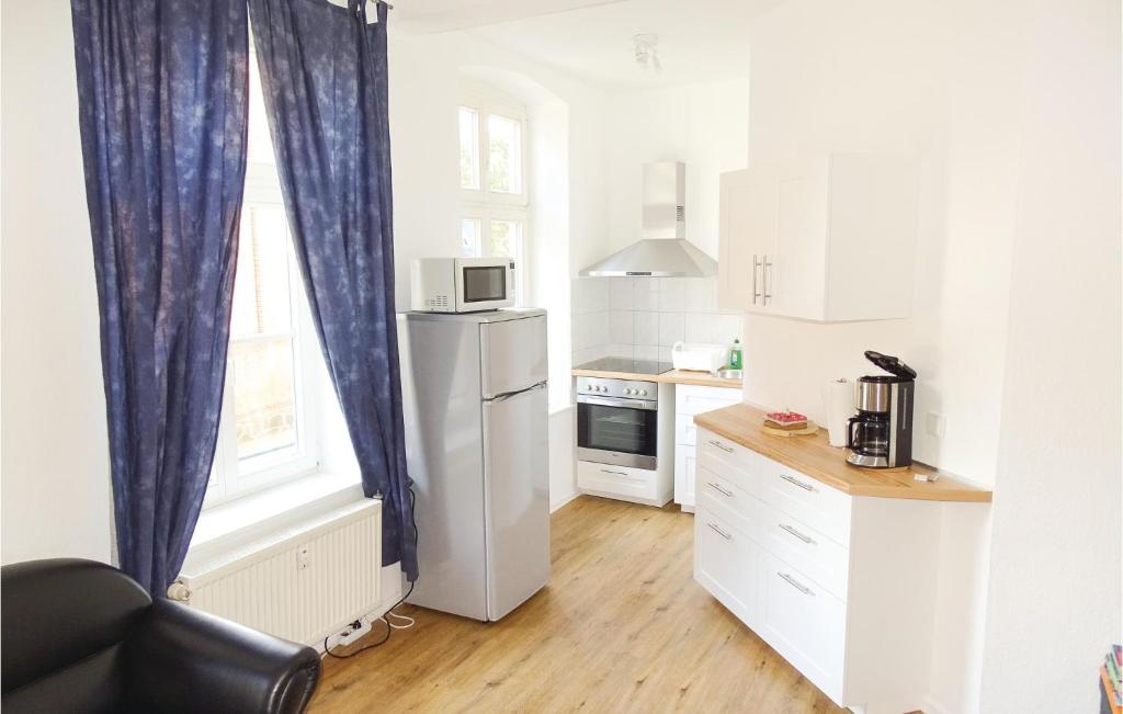 a small kitchen with a refrigerator and a window at 2 Bedroom Awesome Apartment In Wismar in Wismar