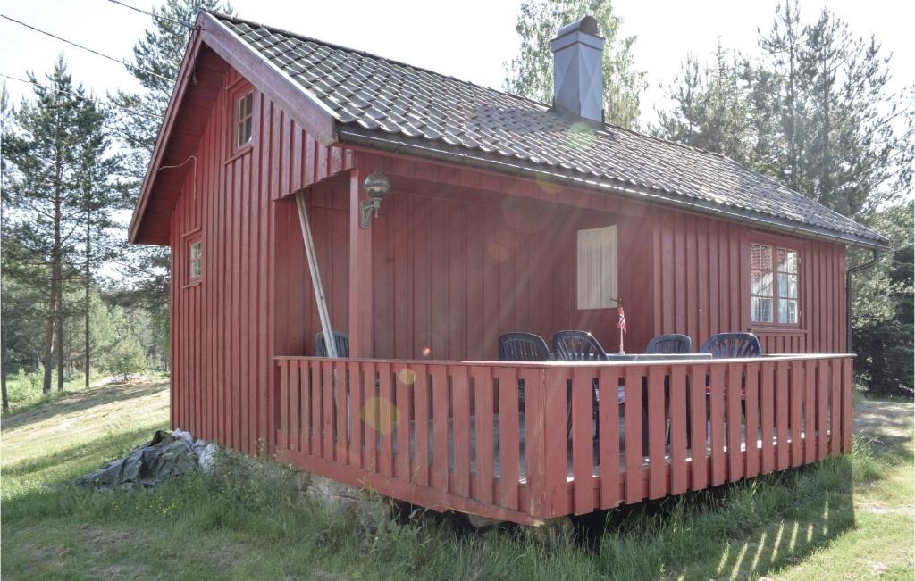 a red house with chairs on the deck at Pet Friendly Home In Sannidal With Kitchenette in Sannidal