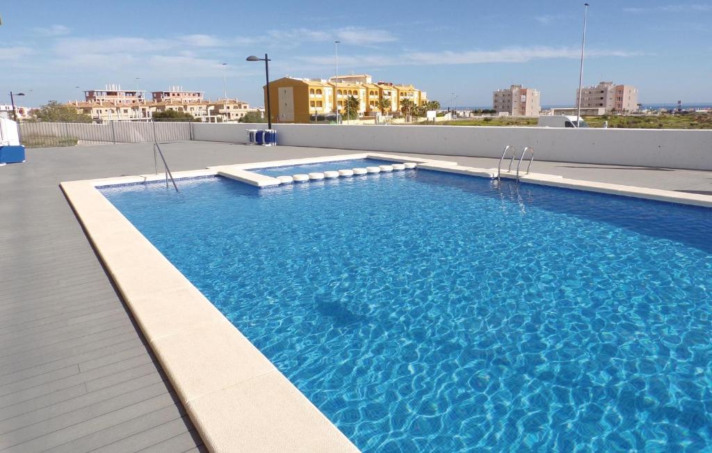 Los Dolses的住宿－2 Bedroom Lovely Apartment In Orihuela Costa，一座大型蓝色游泳池,位于一座建筑的顶部
