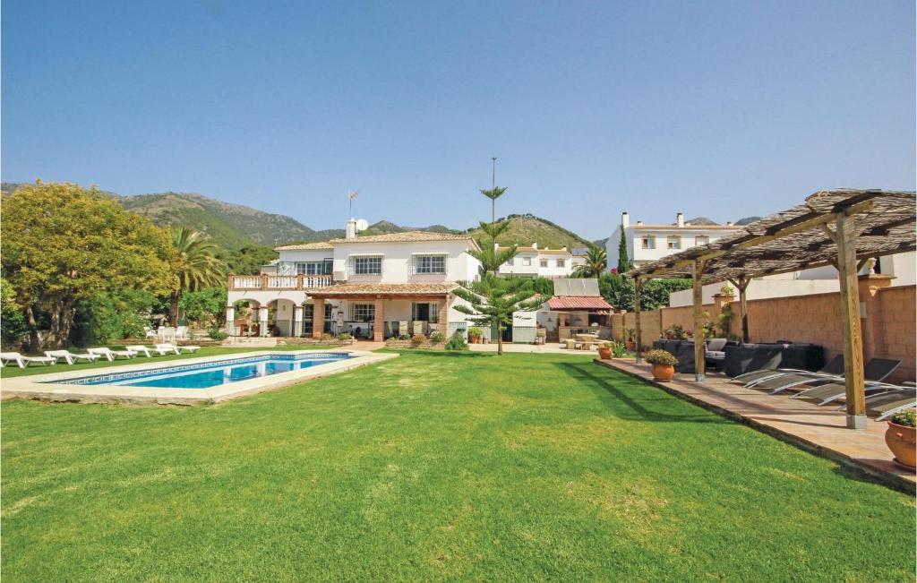 ミハスにあるNice Home In Mijas Pueblo With 5 Bedrooms, Wifi And Outdoor Swimming Poolのスイミングプールと家のある広い庭