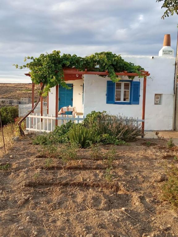 a small white house with a blue door at Alatsaria House in Cherronisos