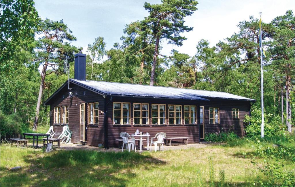 uma cabana de madeira com mesas e cadeiras à sua frente em Nice Home In Ystad With Kitchen em Ystad