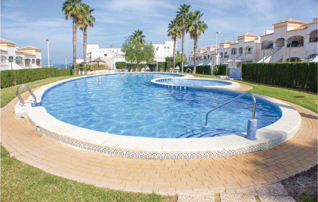 - une grande piscine dans une cour bordée de palmiers dans l'établissement Lovely Apartment In Gran Alacant With Kitchen, à Santa Pola