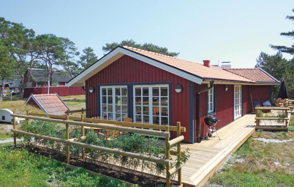 BorrbyにあるAmazing Home In Borrby With 2 Bedrooms, Sauna And Wifiの赤い家 庭園付きのデッキ付