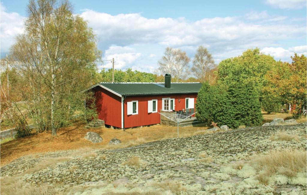 a red house in the middle of a forest at Cozy Home In Torhamn With Kitchen in Torhamn