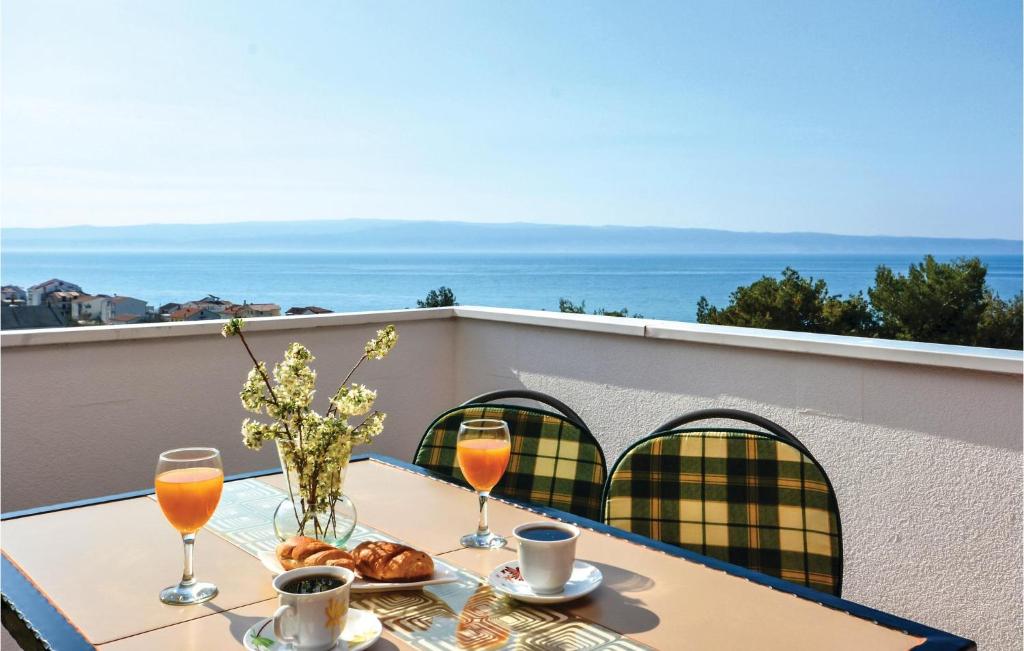 einen Tisch mit Getränken und Croissants auf dem Balkon in der Unterkunft Awesome Apartment In Podstrana With House Sea View in Podstrana