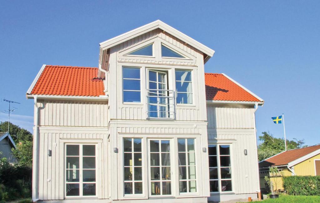 ハンブルクスンドにあるStunning Home In Hamburgsund With 3 Bedrooms And Wifiのオレンジ色の屋根の白い家