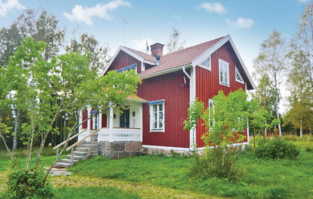 a red house in a field with trees at 3 Bedroom Nice Home In Mariannelund in Svenstorp