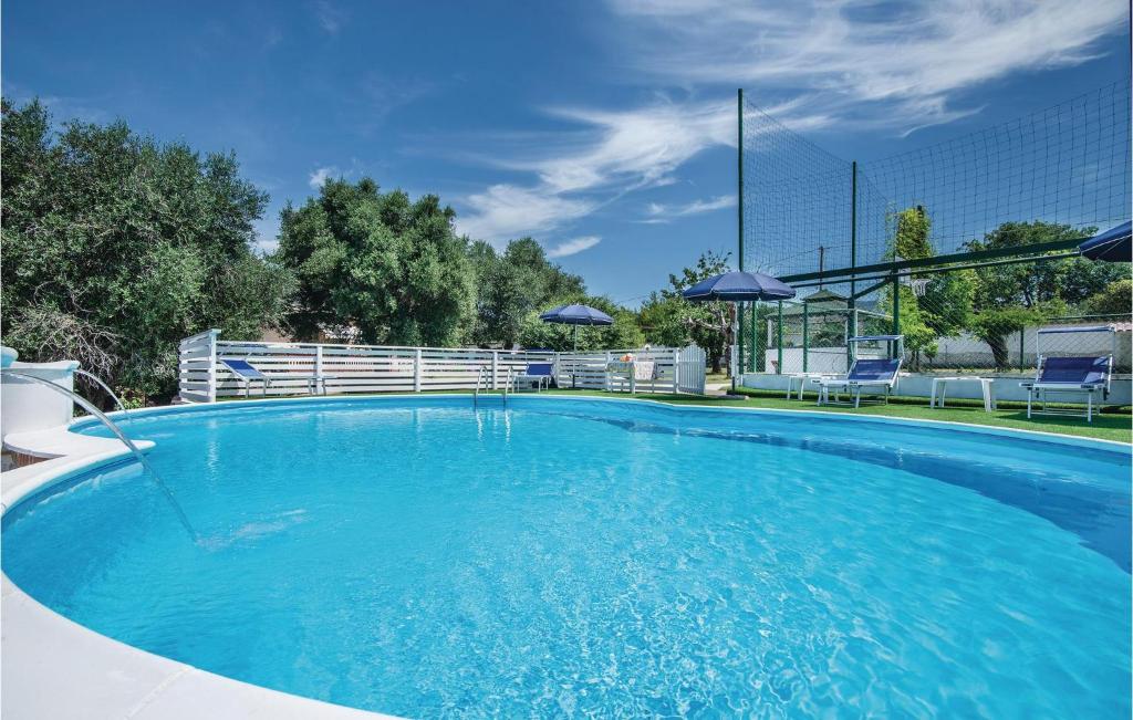 a large blue swimming pool with chairs and umbrellas at Awesome Home In Santangelo Romano With Wifi in SantʼAngelo Romano