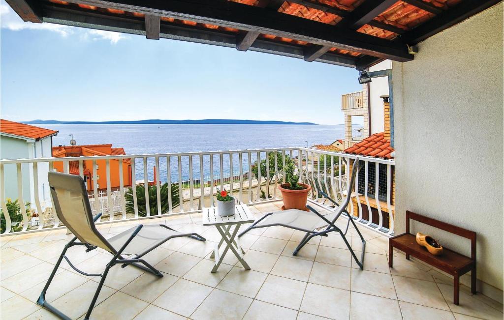 balcón con mesa, sillas y vistas al océano en 1 Bedroom Amazing Apartment In Okrug Gornji en Trogir