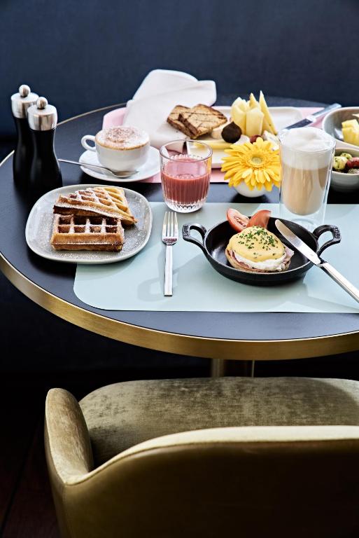 a table with a tray of breakfast foods on it at SIDE, Hamburg, a Member of Design Hotels in Hamburg
