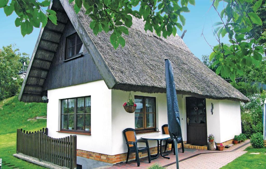 ein kleines Cottage mit einem Tisch und einem Strohdach in der Unterkunft Ferienhaus Waldstr. R in Groß Dratow