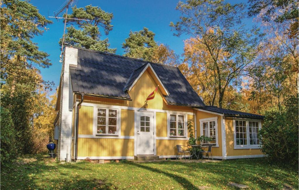 a small yellow house with a black roof at Three-Bedroom Holiday Home In Ystad in Ystad