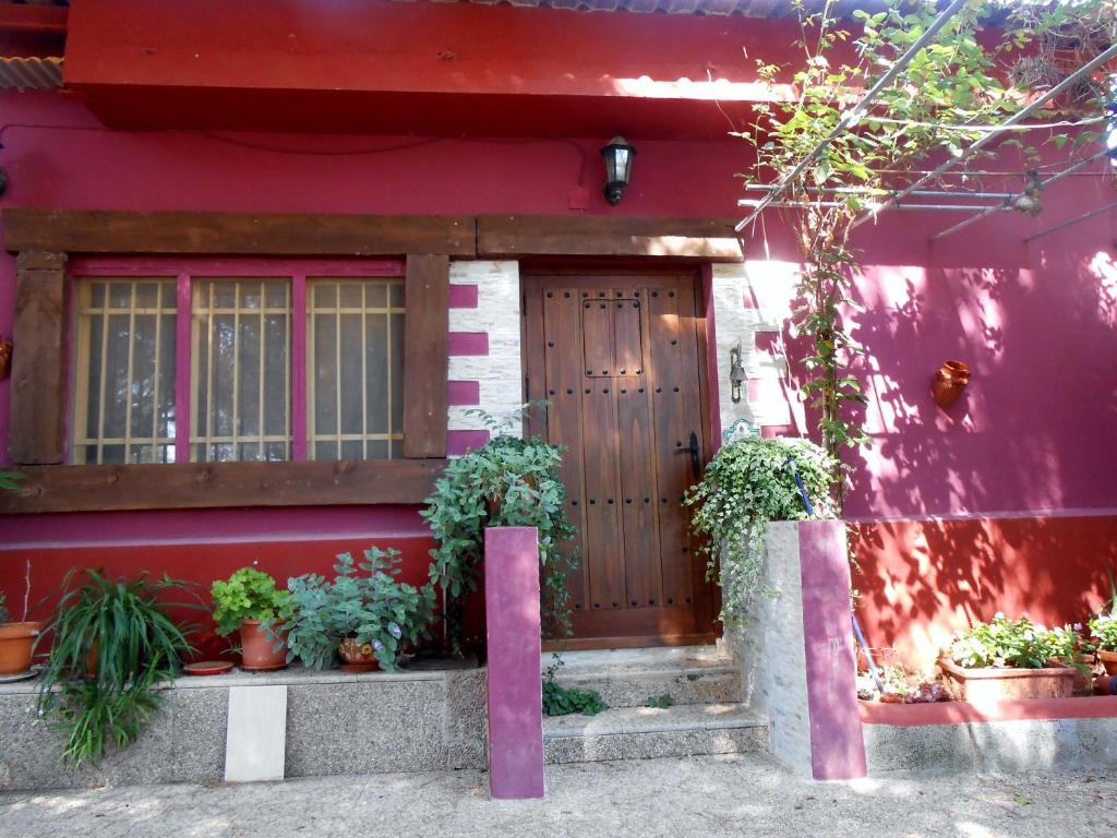 una casa roja con macetas delante de ella en La Derrubiá, en Villamalea