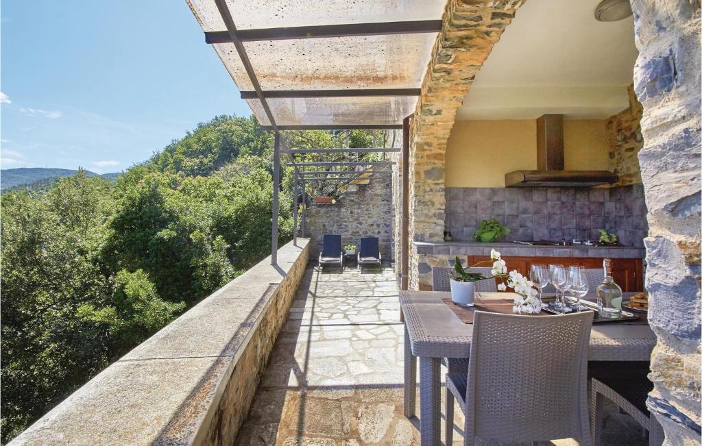 an outdoor patio with a table and chairs and a kitchen at Casa Castelli in Garlenda
