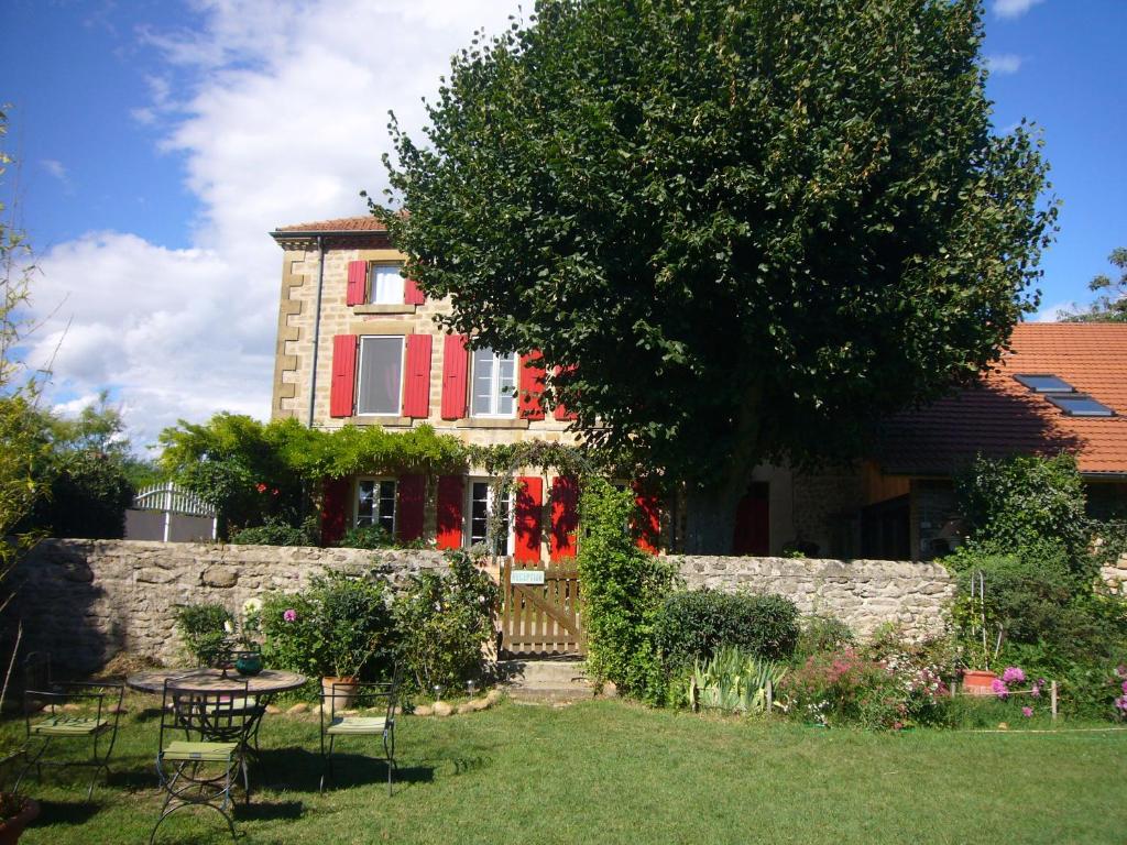 a house with a tree and a table in a yard at Chambres d'hôtes Les 7 Semaines in Chantemerle-les-Blés