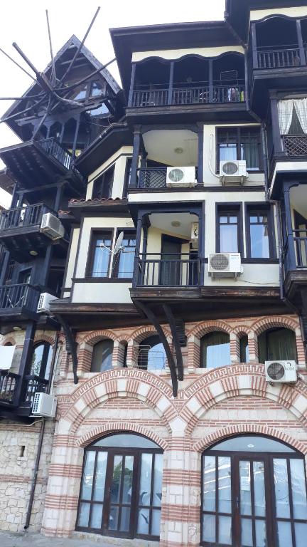 a tall brick building with windows and balconies on it at Апартамент с изглед море и Стария Несебър in Nesebar