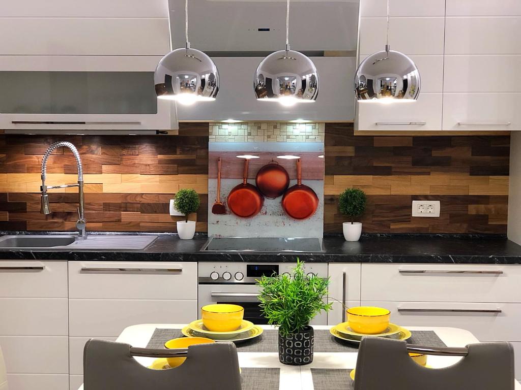 a kitchen with white cabinets and a table with yellow dishes at Villa Danmarie in Vinišće