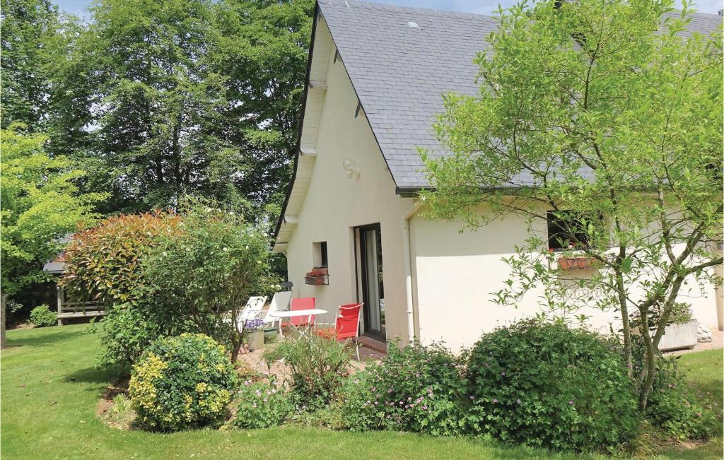 une maison blanche avec des chaises rouges dans la cour dans l'établissement Beautiful Home In Ectot Lauber With 1 Bedrooms And Wifi, à Ectot-lʼAuber