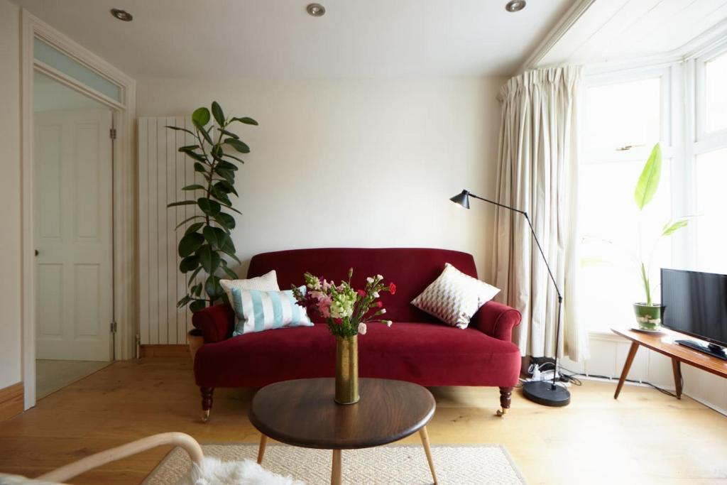 a living room with a red couch and a table at Host & Stay - Dane Hill in Margate