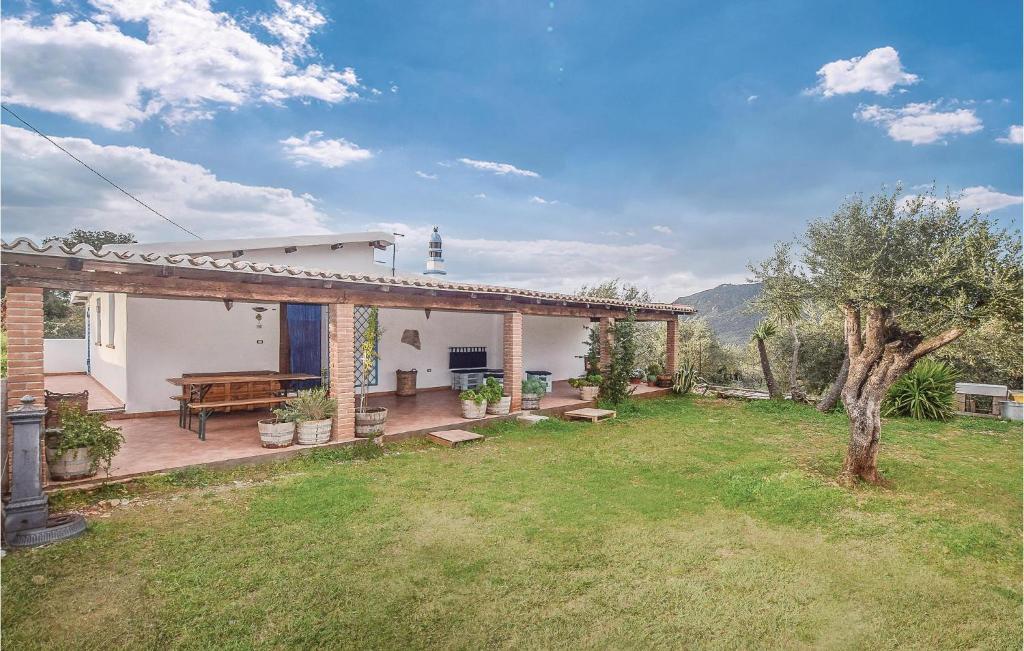 una casa con un patio con una mesa y un árbol en Villa Antonietta, en Oliena