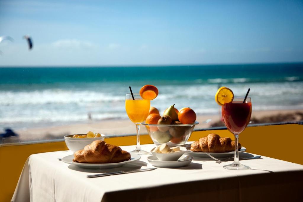 una mesa con un plato de comida y bebida en la playa en Arte Vida en Tarifa