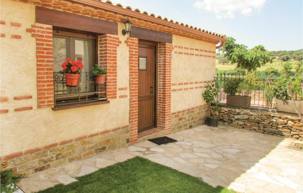 een stenen huis met een deur en een patio bij Nice Home In Aldeanue, De La Sierra With Ethernet Internet in Aldeanueva de la Sierra