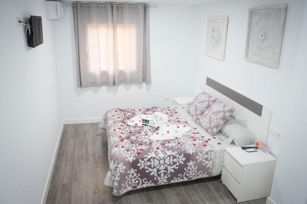 a small bedroom with a bed with a table on it at Hostal Goyesco Plaza in Plasencia