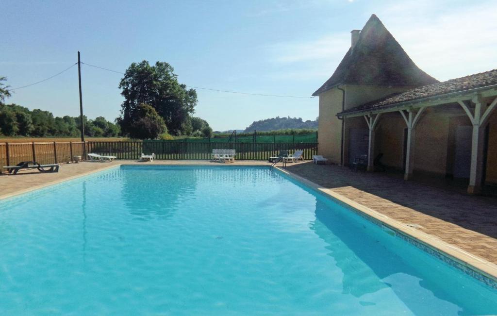 a large blue swimming pool next to a house at Stunning Apartment In Limeuil With 2 Bedrooms in La Terrasse