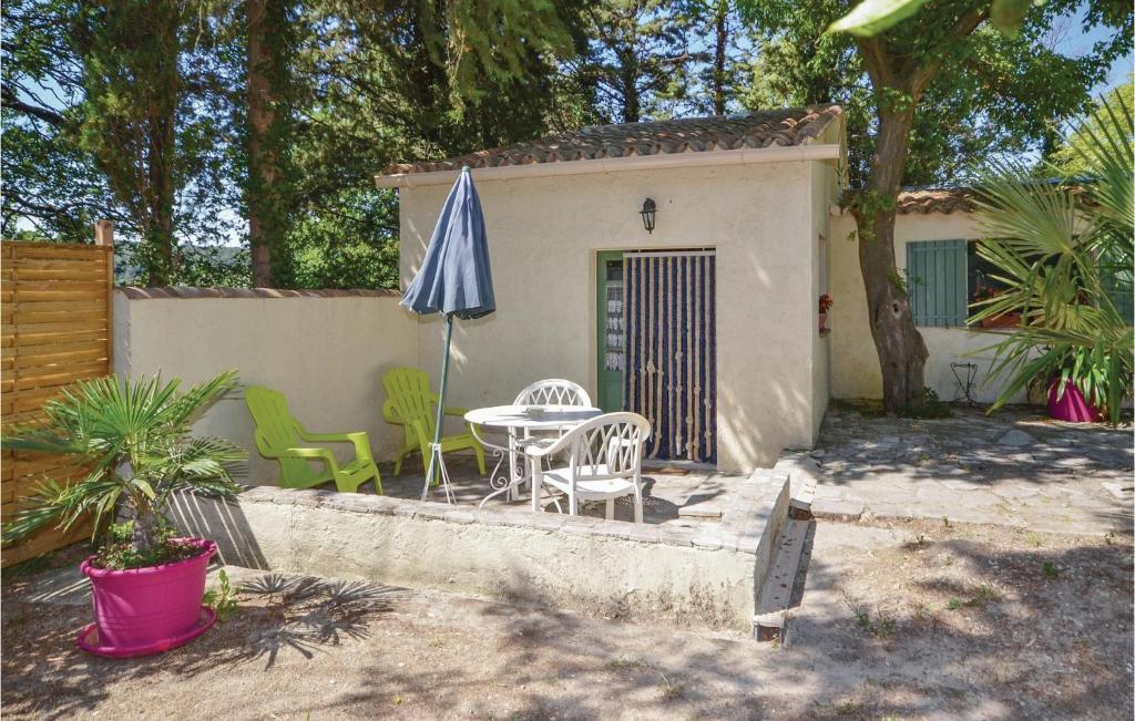 um pátio com um guarda-sol, uma mesa e cadeiras em Gorgeous Home In Crillon Le Brave With Wifi em Crillon-le-Brave