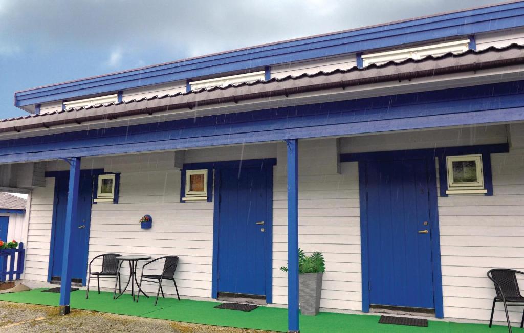 een huis met blauwe deuren en een tafel en stoelen bij Stunning Apartment In Agdenes With Kitchenette in Selva
