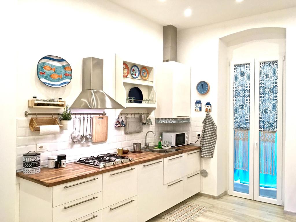 a kitchen with white cabinets and a stove top oven at Mare&Sentieri Apartment in La Spezia