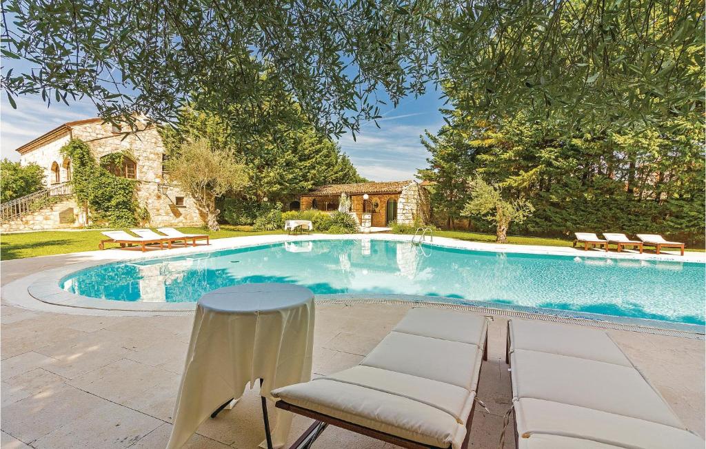 貝爾的住宿－Nice Home In Bale With House A Panoramic View，一个带椅子和桌子的游泳池
