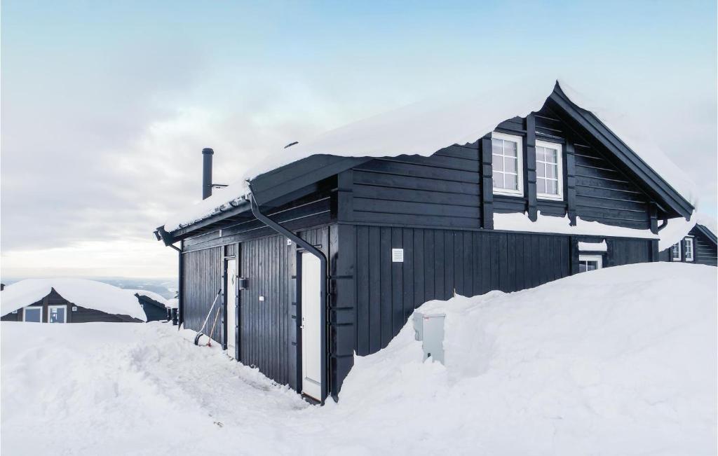 a building covered in snow with a pile of snow at Stunning Home In Lillehammer With 4 Bedrooms And Wifi in Lillehammer