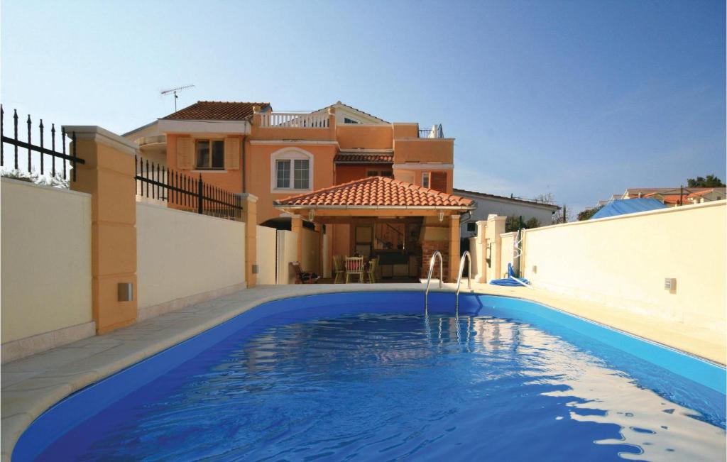 - une piscine en face d'une maison dans l'établissement Gorgeous Home In Brodarica With Kitchen, à Brodarica