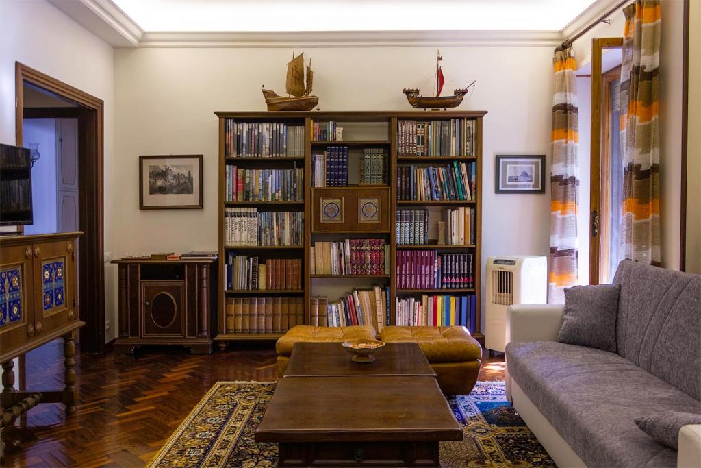 a living room with a couch and book shelves filled with books at Casa dei Laghi in Viterbo