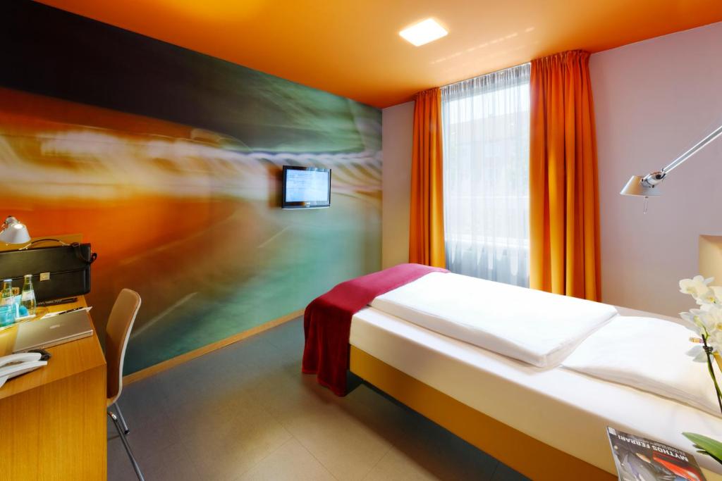 ミュンヘンにあるホテル ケニンシュタインのベッドと窓が備わるホテルルーム
